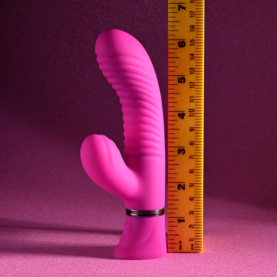 Pink dual silicone G-spot vibrator with ribbed texture and curved tip, measured against a ruler.
