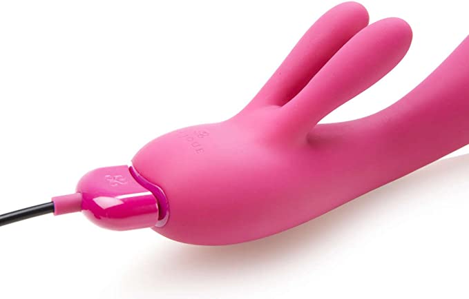 Pink silicone rabbit vibrator with a charging cable.