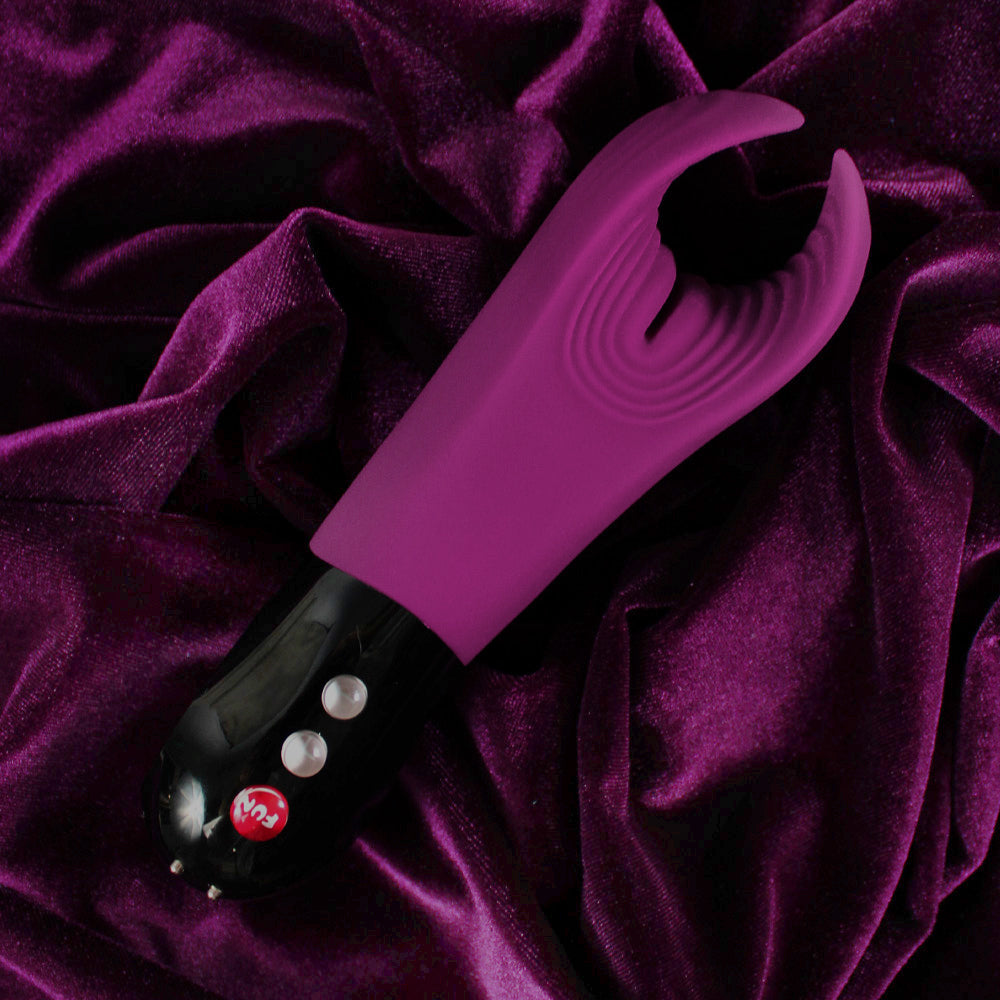 A purple textured stroker and vibrator with a black base and buttons.