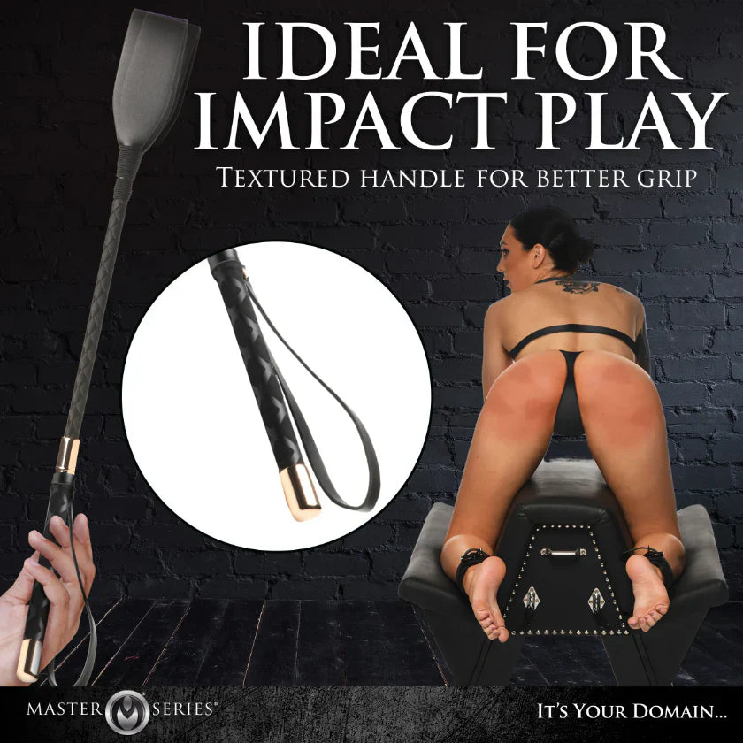 Black vegan leather riding crop with textured grip and gold accents.