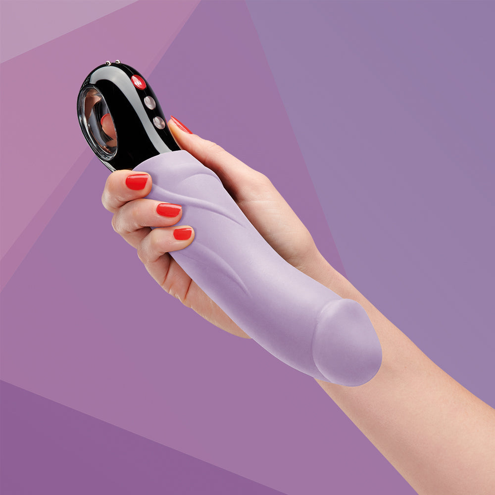 A purple G-spot vibrator with a black control head held in a hand.