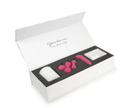 A white gift box containing a pink G-spot bullet, pink kegel balls, a white candle, and a box of treats.