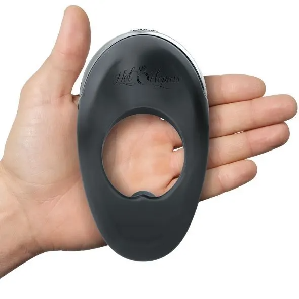 Atom Plus dual motor rechargeable silicone cock ring in black, held in a hand.