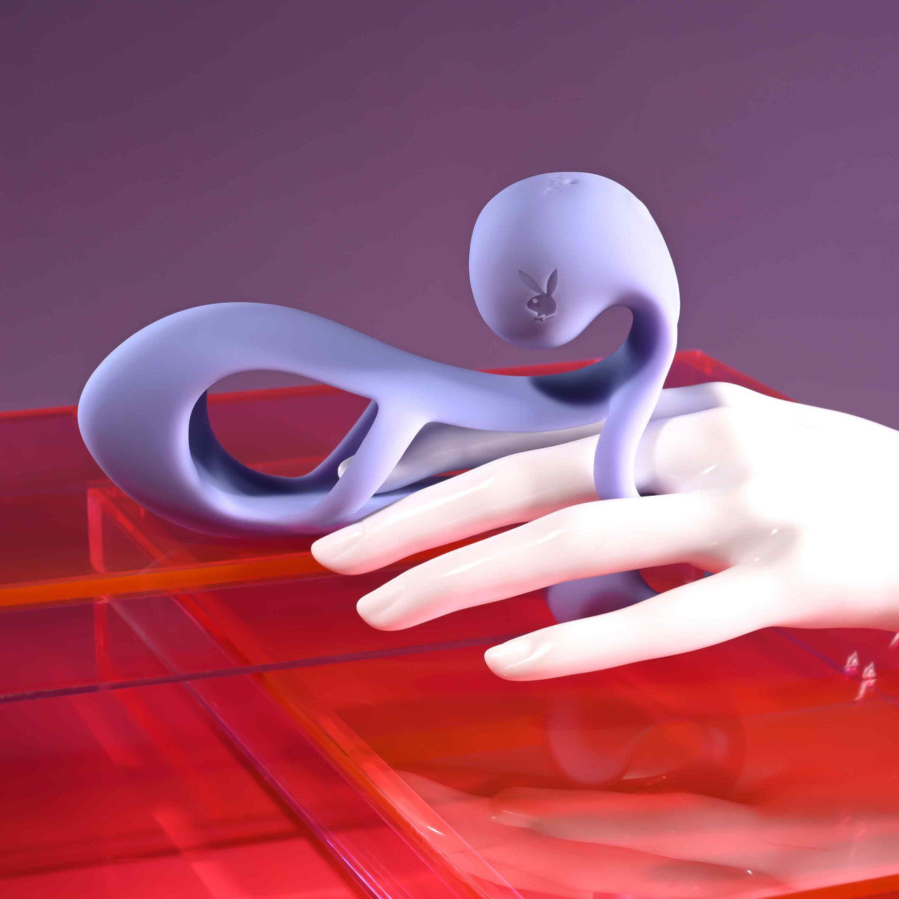 A purple silicone vibrating penis enhancer cage with a Playboy bunny logo rests on a mannequin's hand.