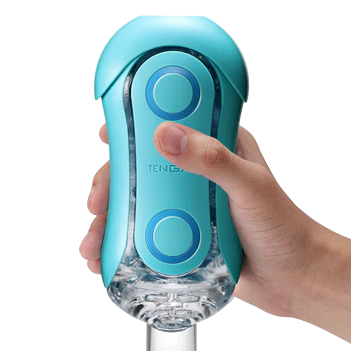 A hand holds a blue Tenga Flip Orb masturbator with two circular buttons.