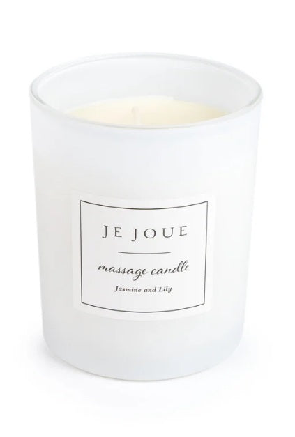 A white frosted glass massage candle with a label that reads "JE JOUE massage candle Jasmine and Lily".