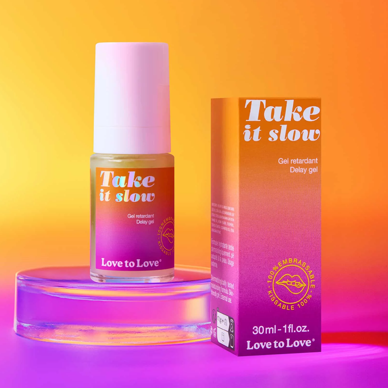 A bottle and box of Love to Love Take it slow delay gel with a gradient background.