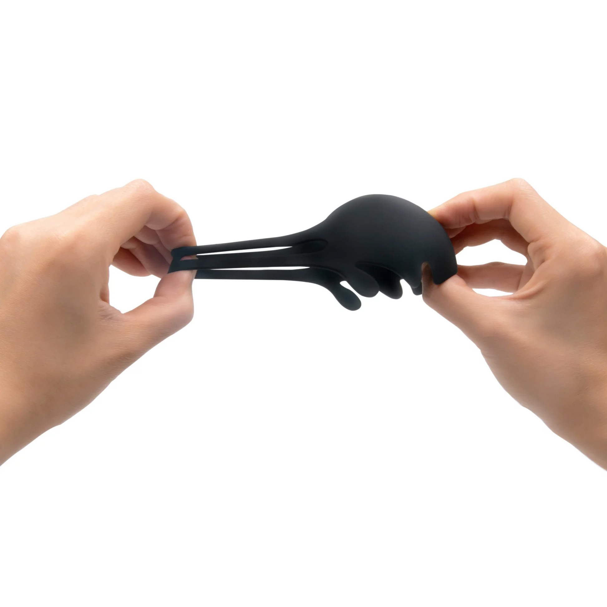 Black silicone penis and testicle stimulator held by two hands.