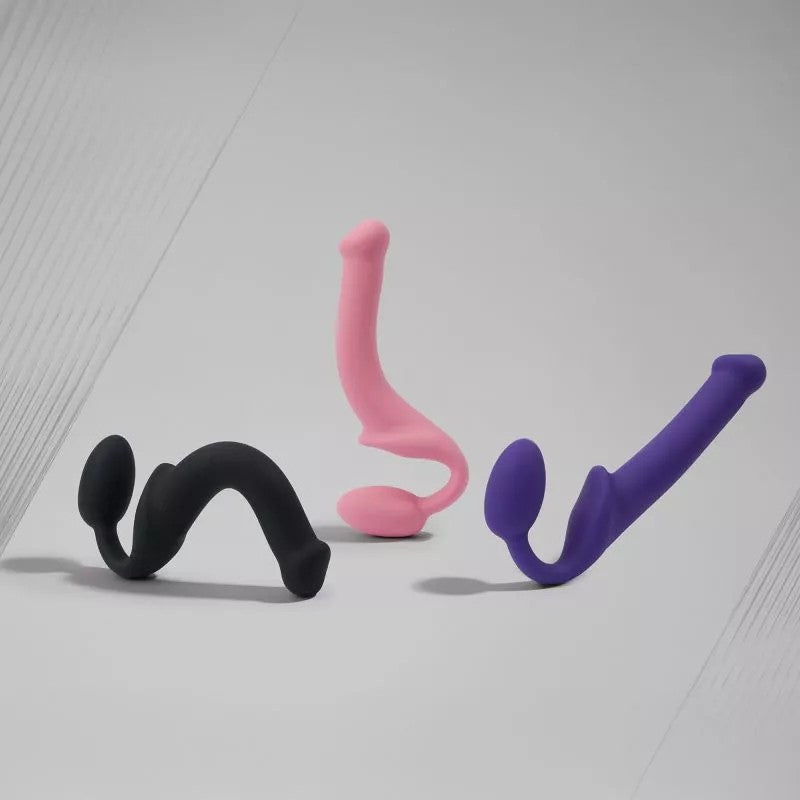 Semi-realistic bendable silicone strap-on dildo in pink with ergonomic curved design.