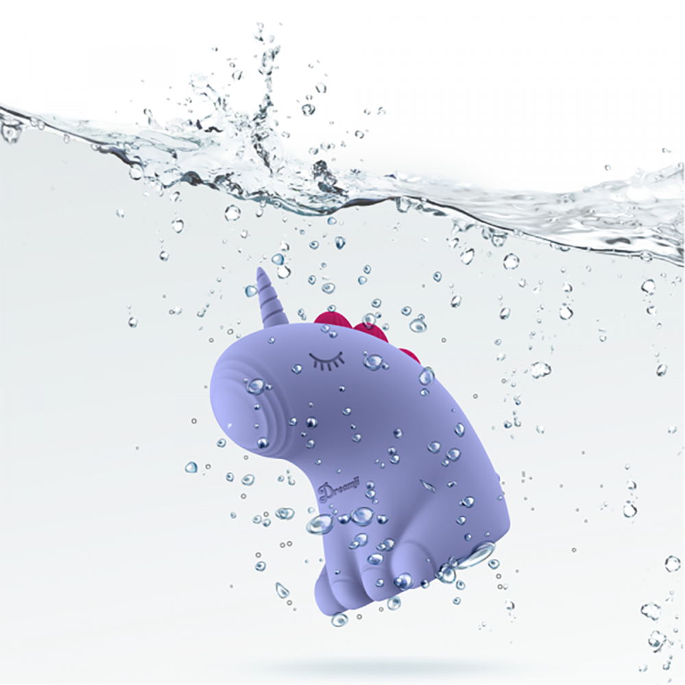 A purple unicorn vibrator with pink ears submerged in water.
