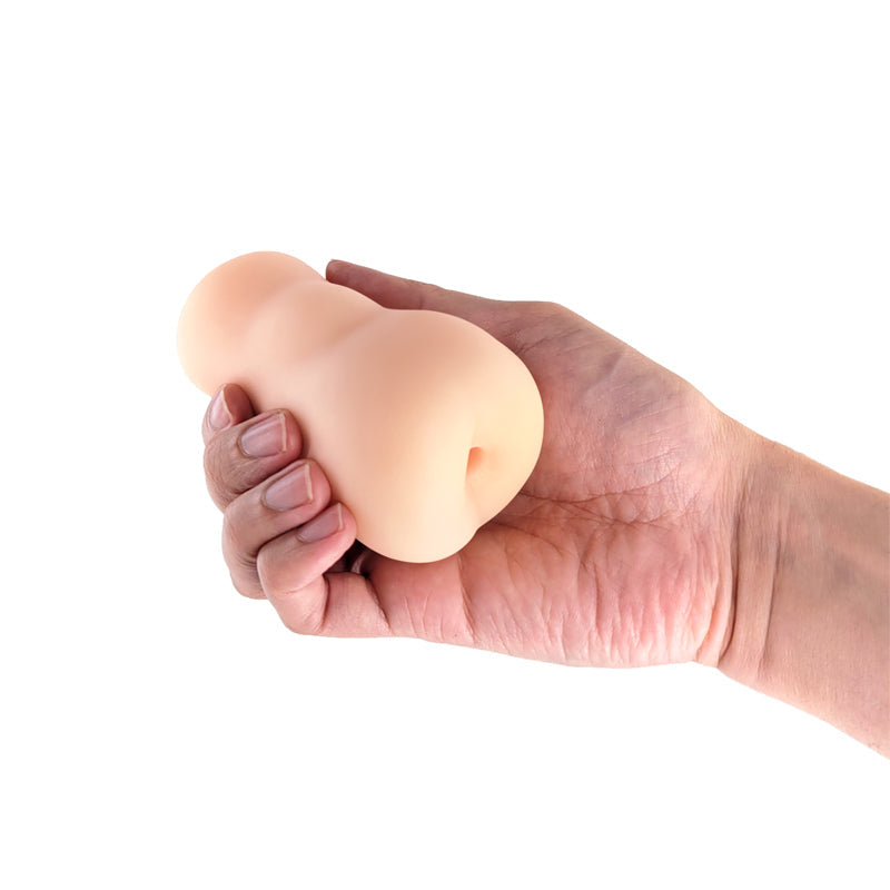 A hand holds a white TPE anal stroker.