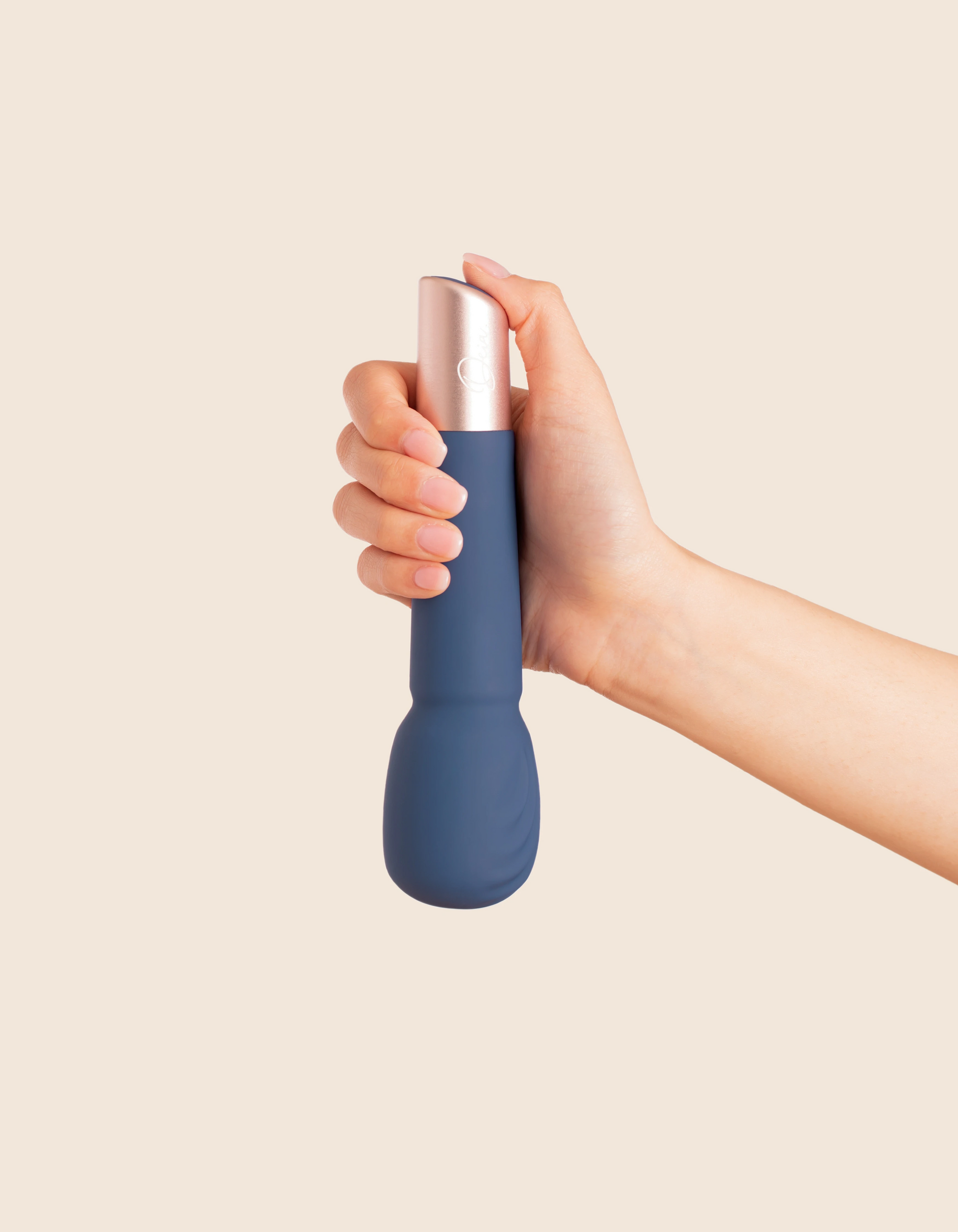 A hand holds a blue and rose gold rechargeable silicone massage wand.