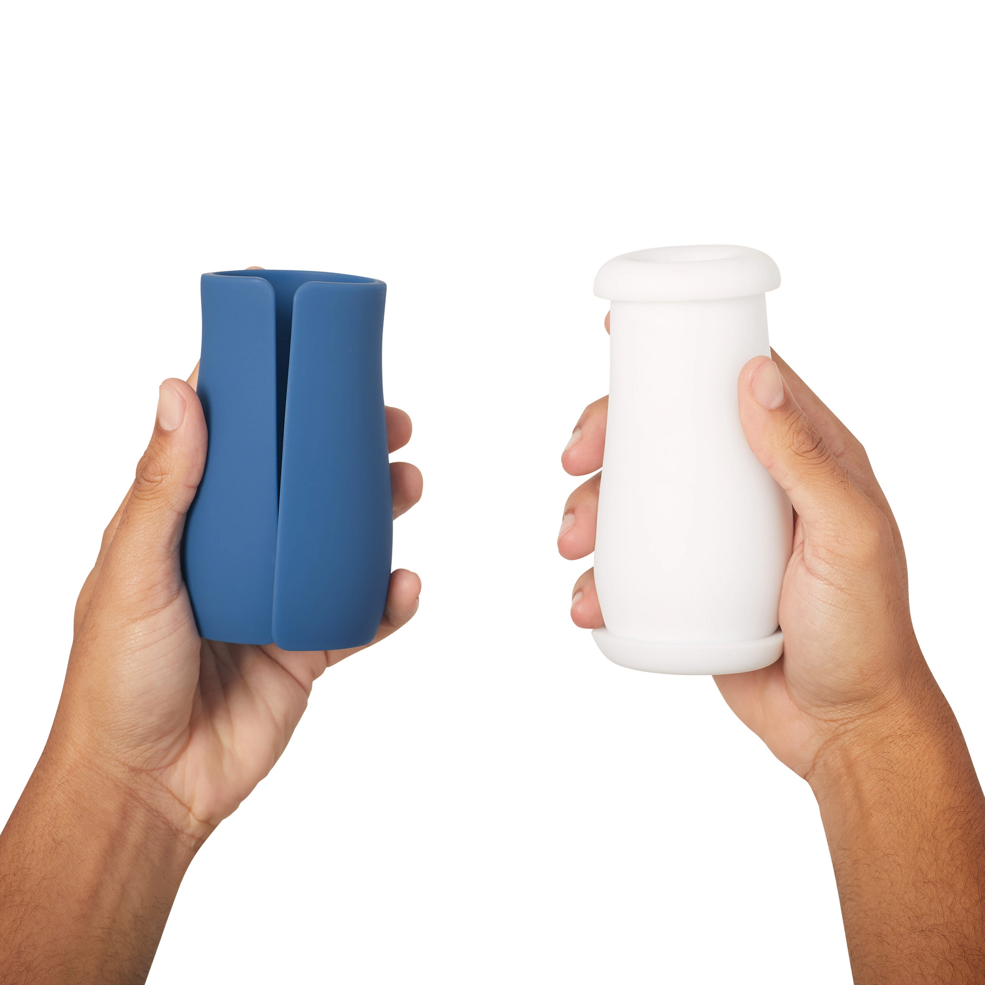 Two hands hold a blue and a white personal stroker.