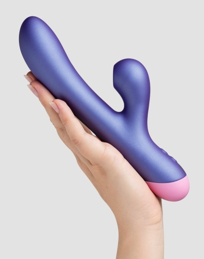 Purple rabbit vibrator with pink tip held in a hand.