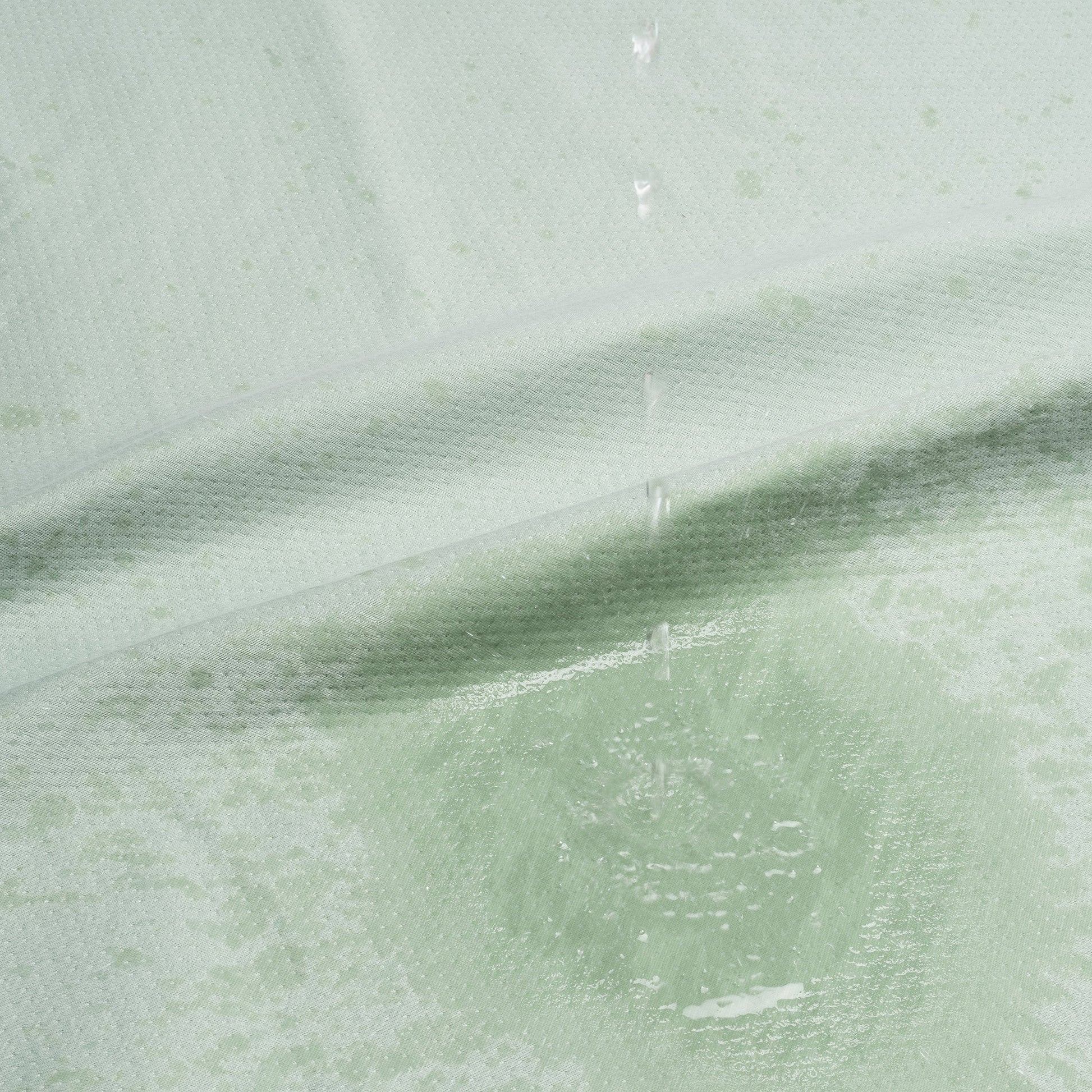 Sage green waterproof cotton blanket with water droplets on it.