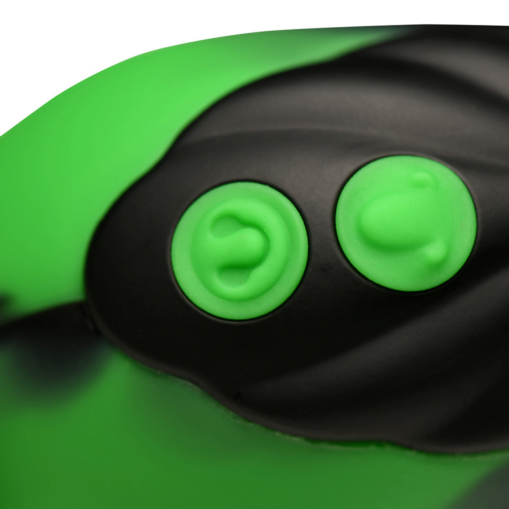 Close-up of a green and black vibrator with two textured green buttons.