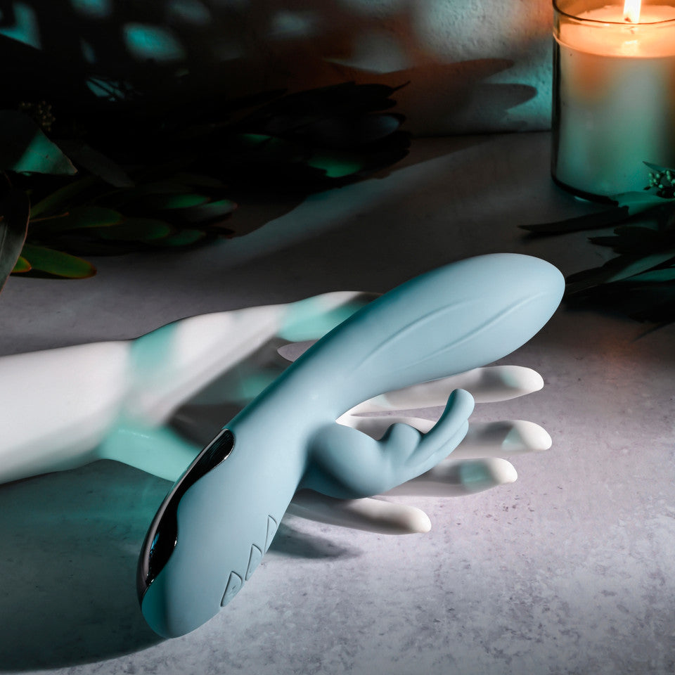 Rechargeable silicone rabbit vibrator in light blue with a curved design.