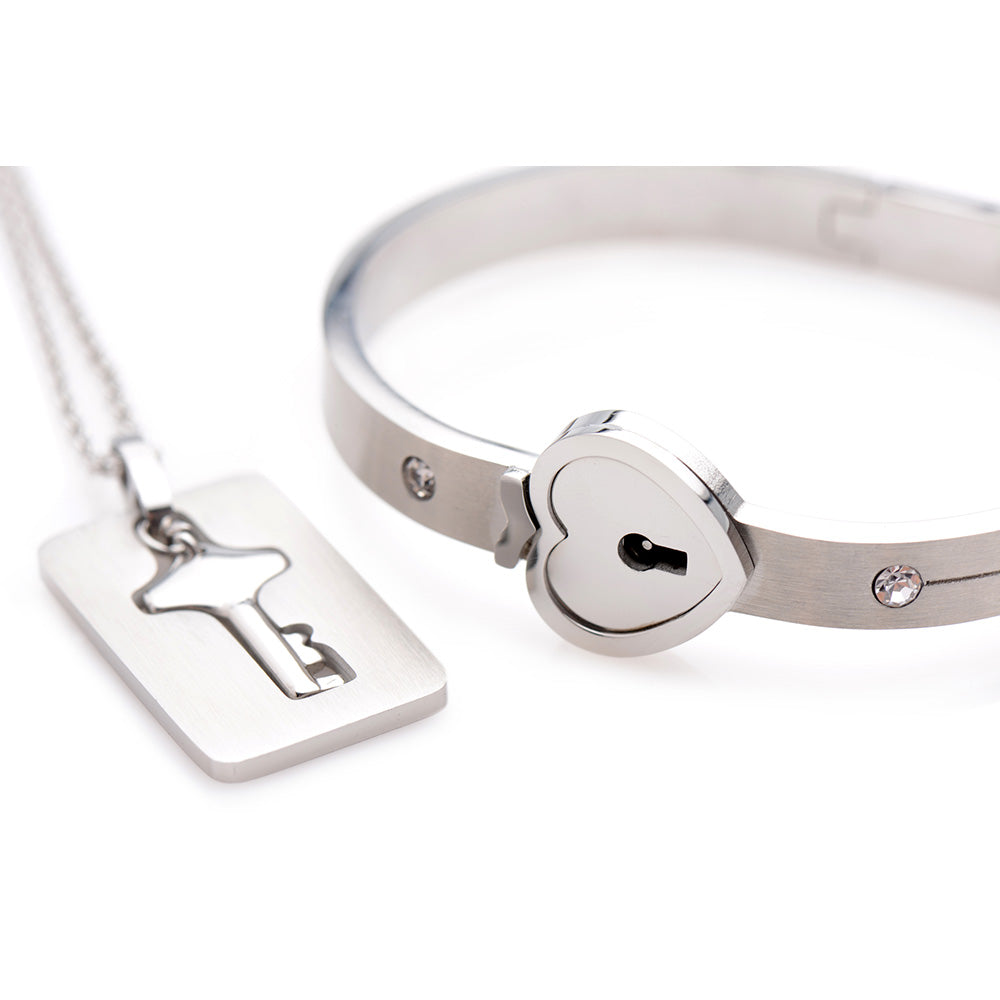 Silver-tone bracelet with a heart-shaped lock and matching key pendant necklace.