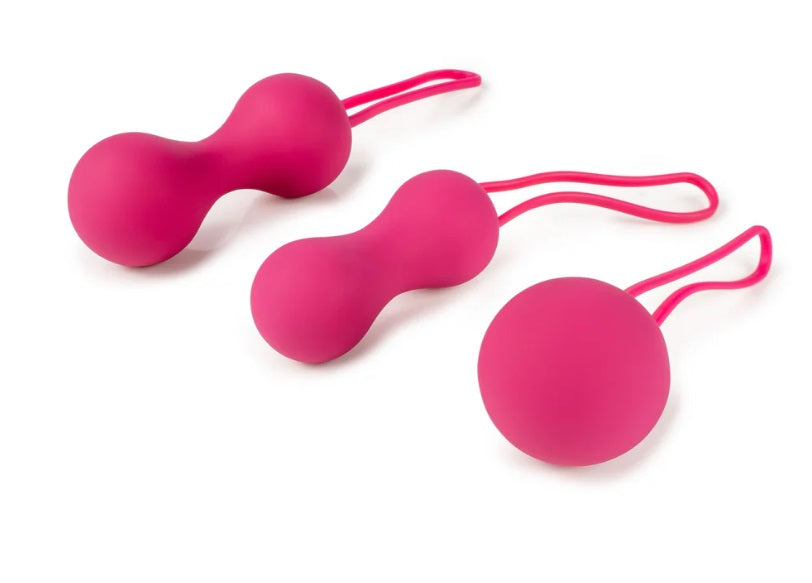 Three pink sex toys with strings on a white background.
