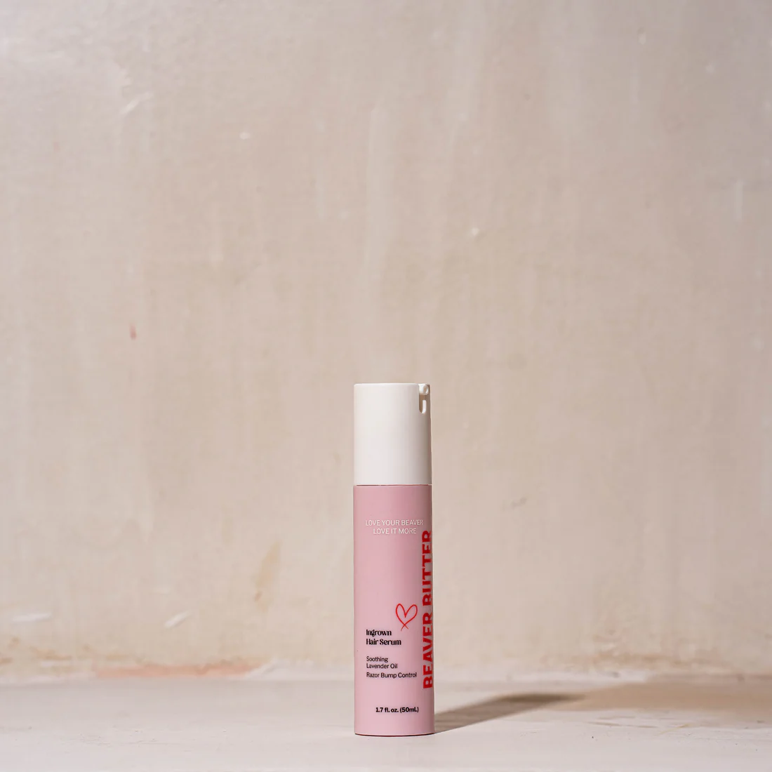 A pink bottle of Beaver Butter Ingrown Hair Serum with a white pump.