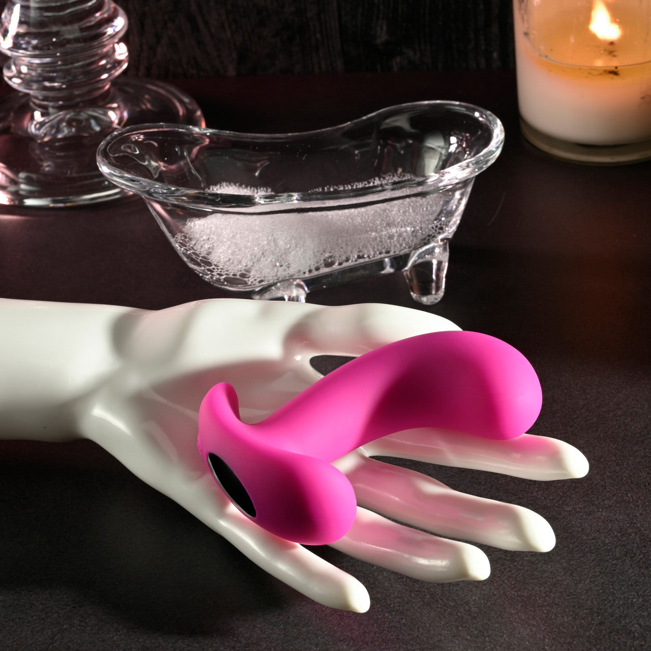 Pink curved prostate massager on a white hand mannequin.