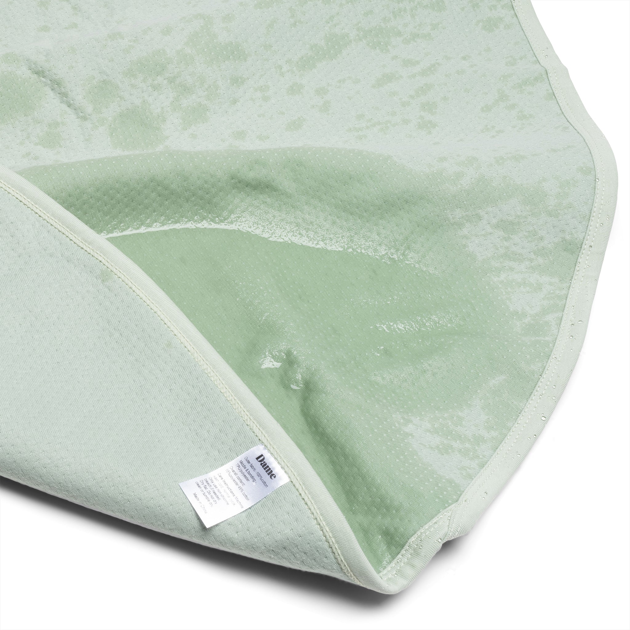 A sage green waterproof cotton blanket with a textured surface.