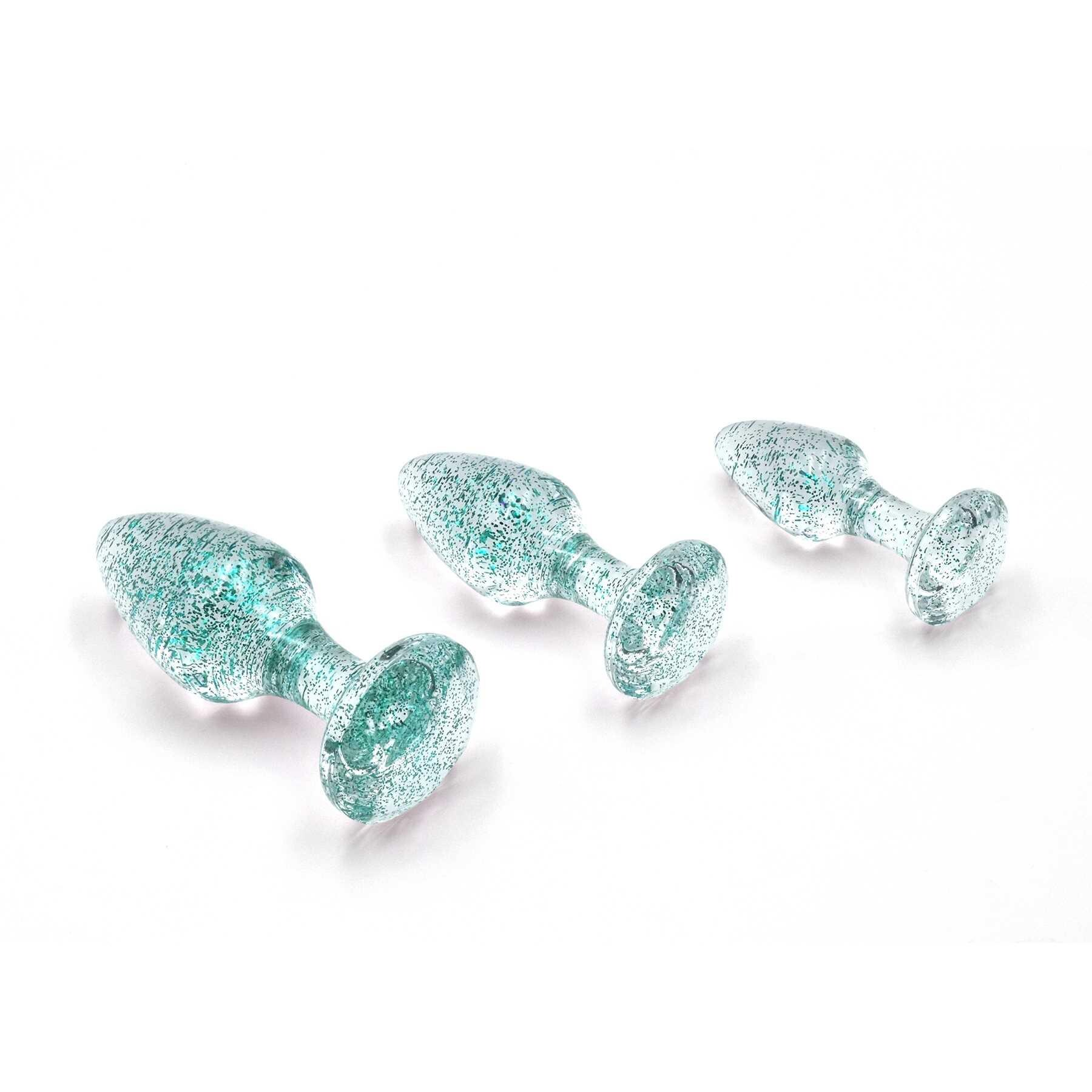 Three blue glitter anal plugs of varying sizes on a white background.