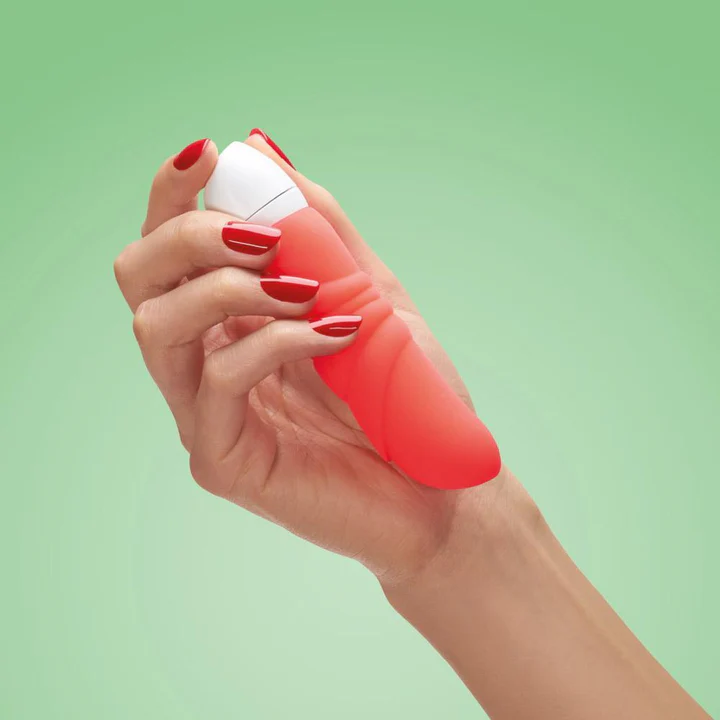 A hand with red nails holds a red ridged vibrator with a white tip.