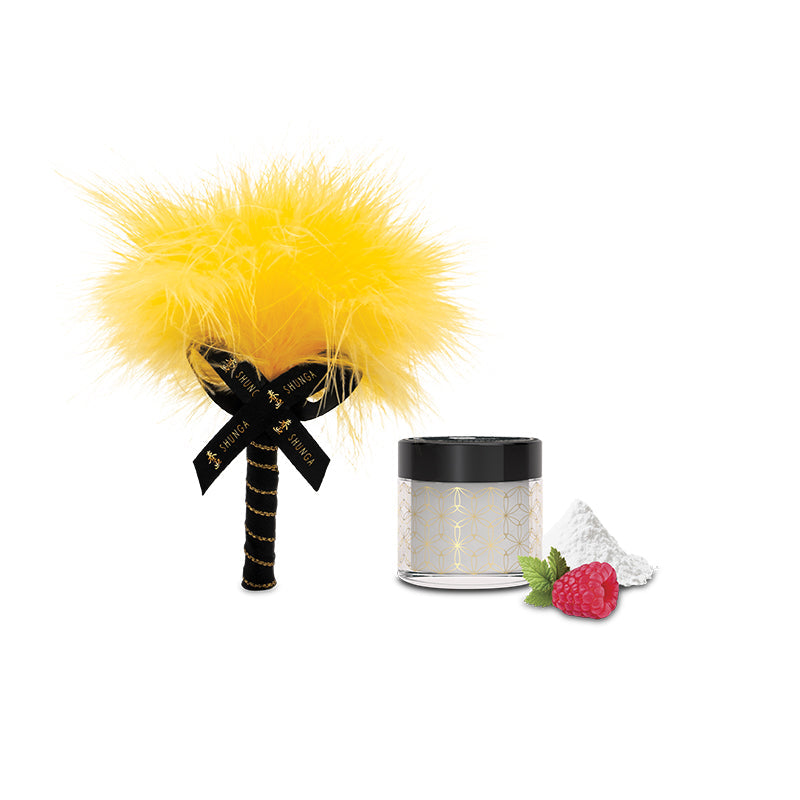 A yellow feather tickler with a black ribbon and a jar of powder with a raspberry.