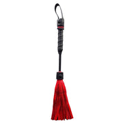 Mini leather flogger with a black handle and red leather fringe.