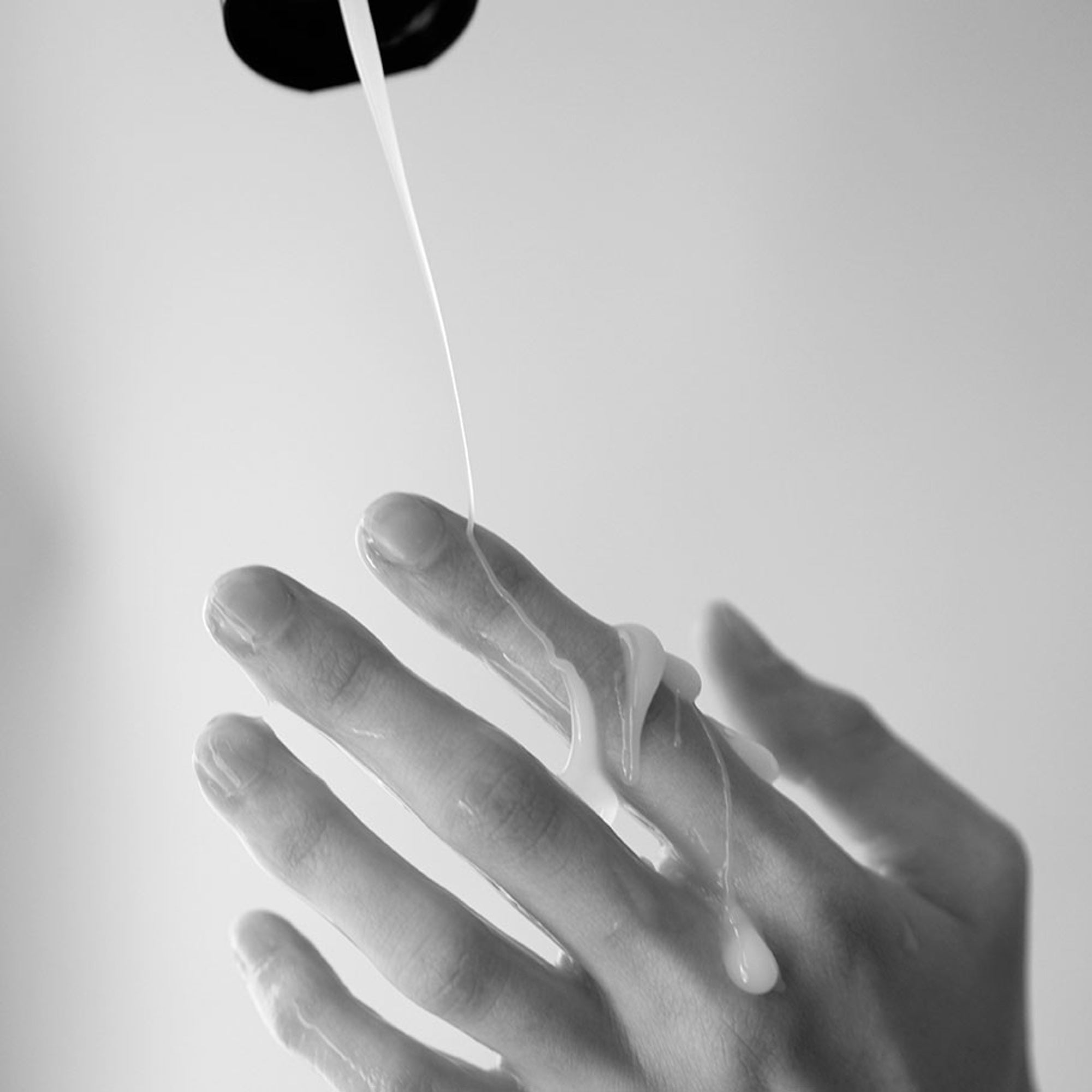 Water-based lubricant with a milky gel texture on fingers.