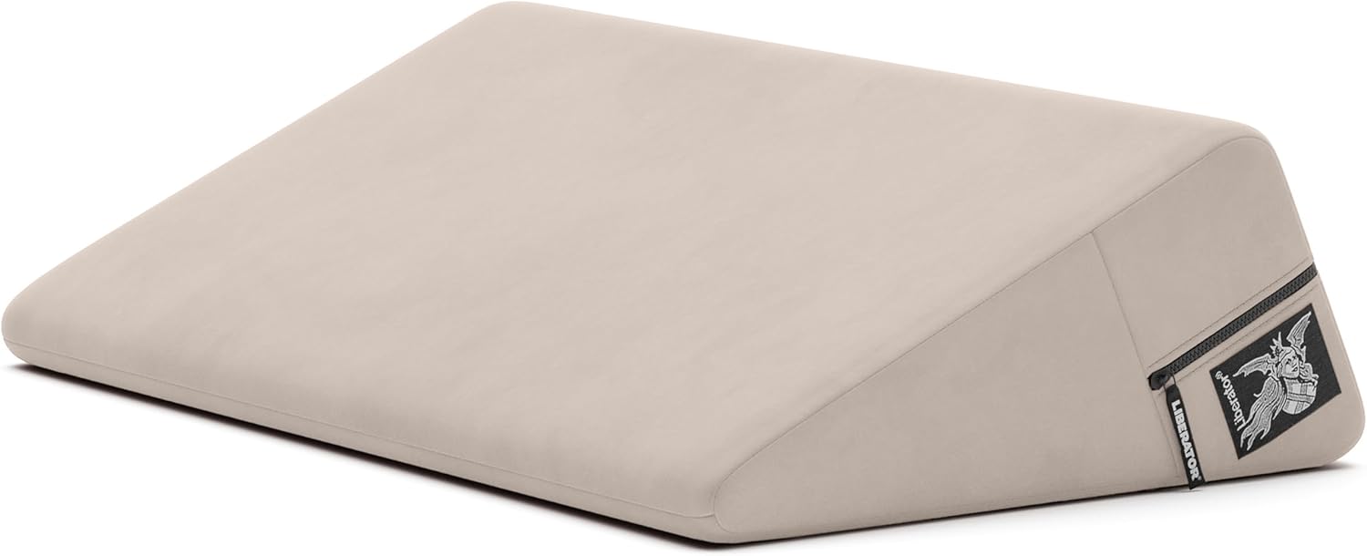 A cream-colored wedge positioning pillow with a zipper and logo.