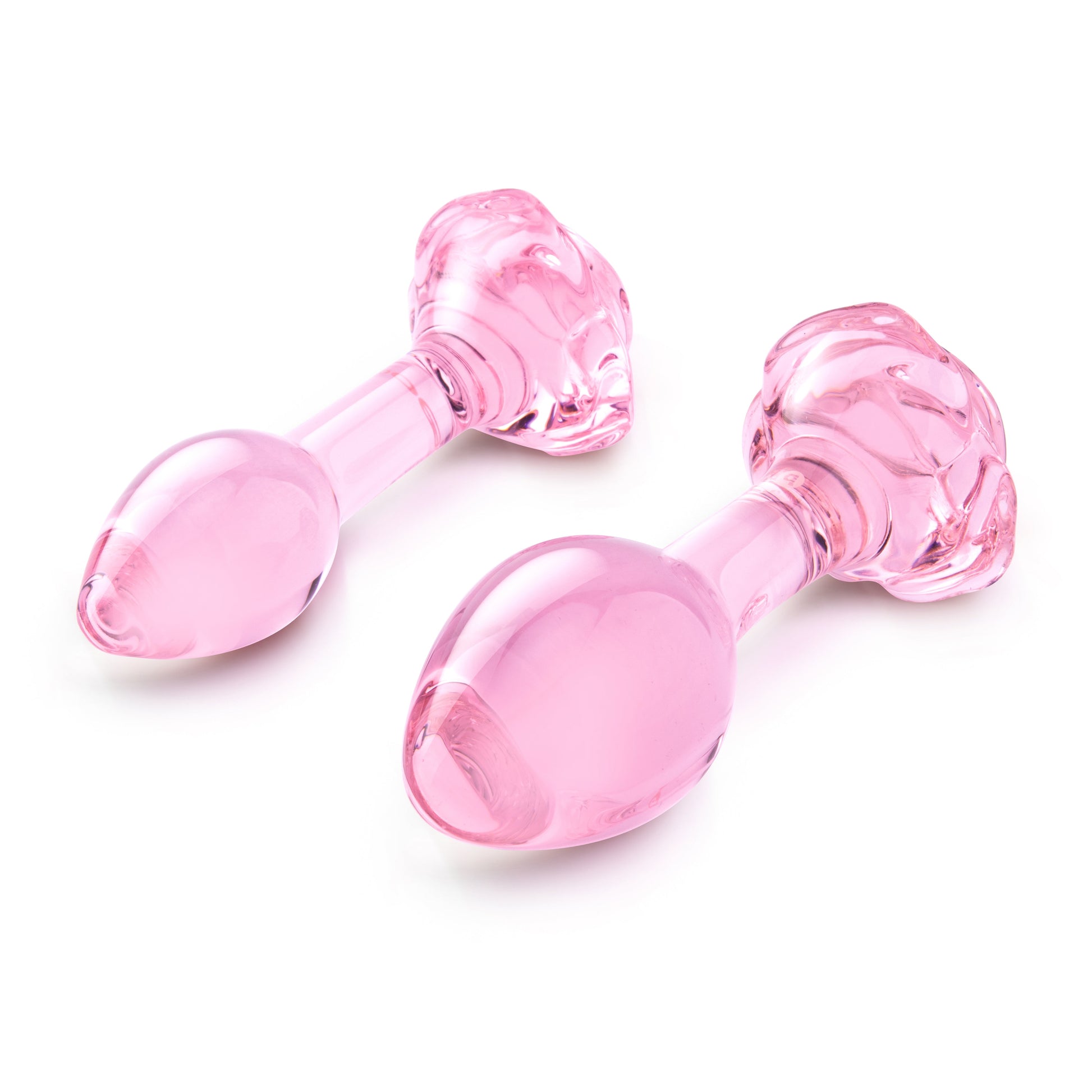 Two pink glass anal plugs with rose-shaped bases.