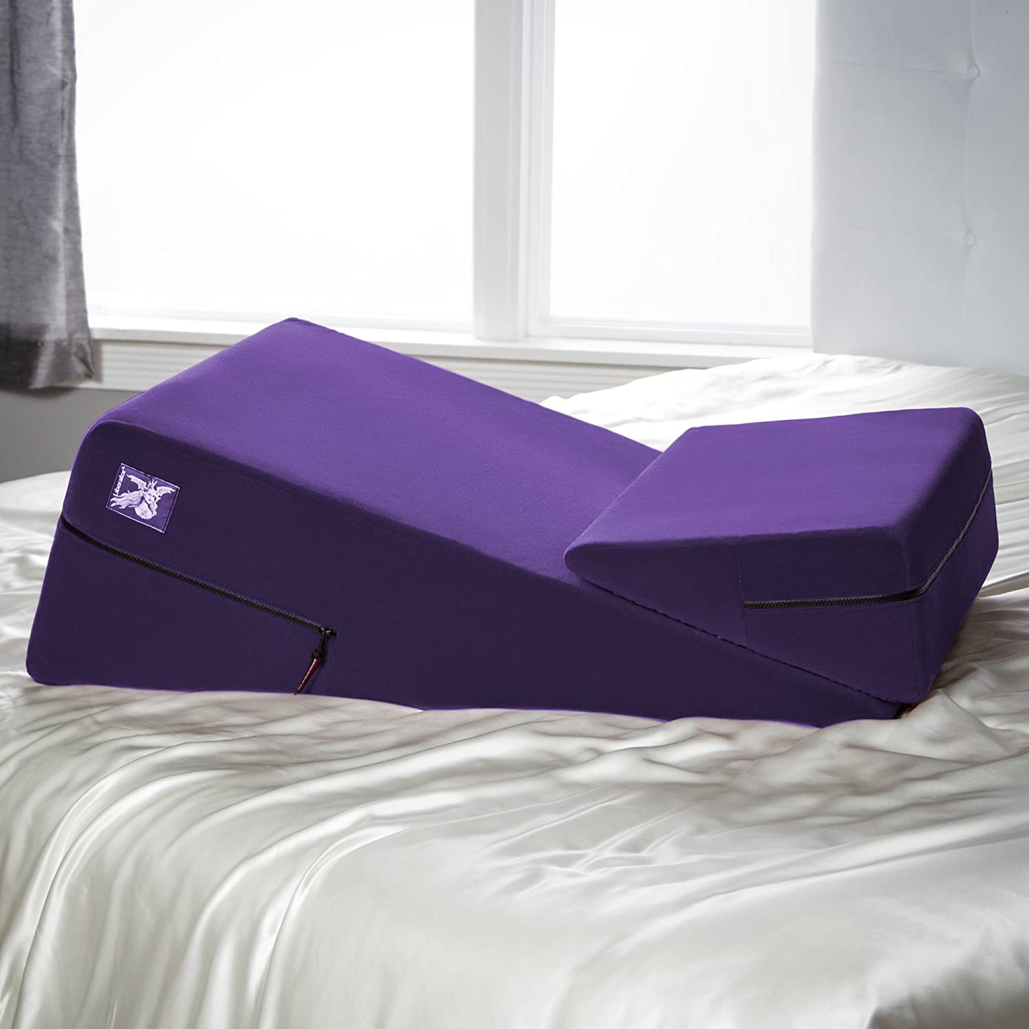 Purple microfiber wedge and ramp combo positioning pillow on a bed.
