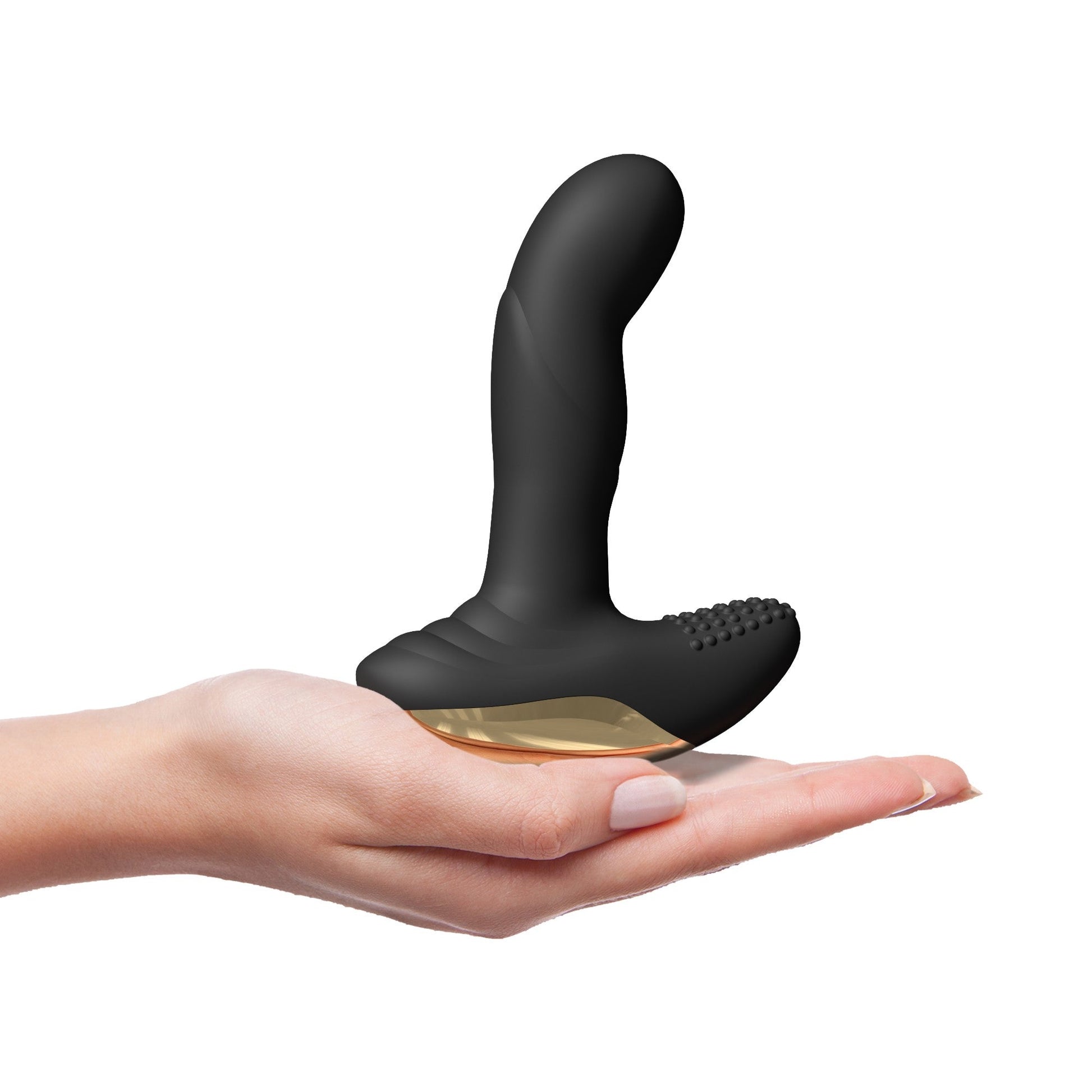 Black remote-controlled vibrator with gold accents held in a hand.