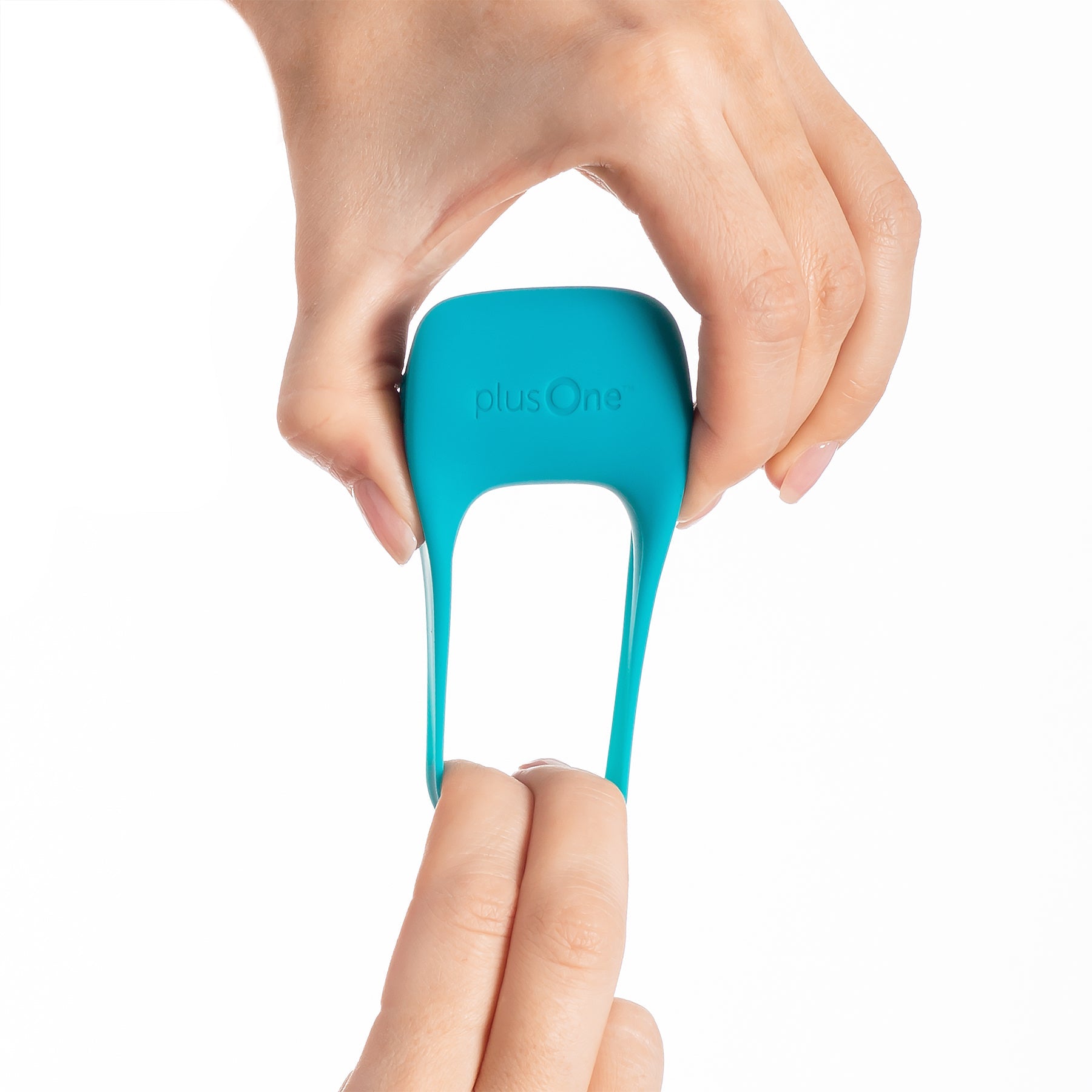 A teal plusOne vibrating cock ring is held by two hands.