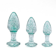 Three blue glitter anal plugs of varying sizes on a white background.