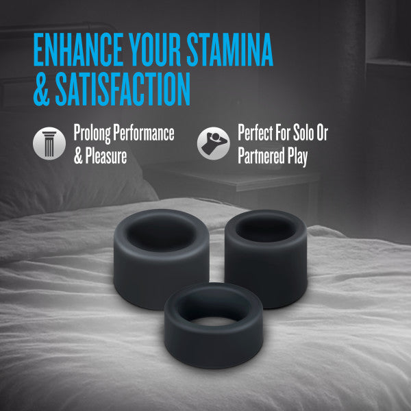 Three black silicone cock rings on a bed.