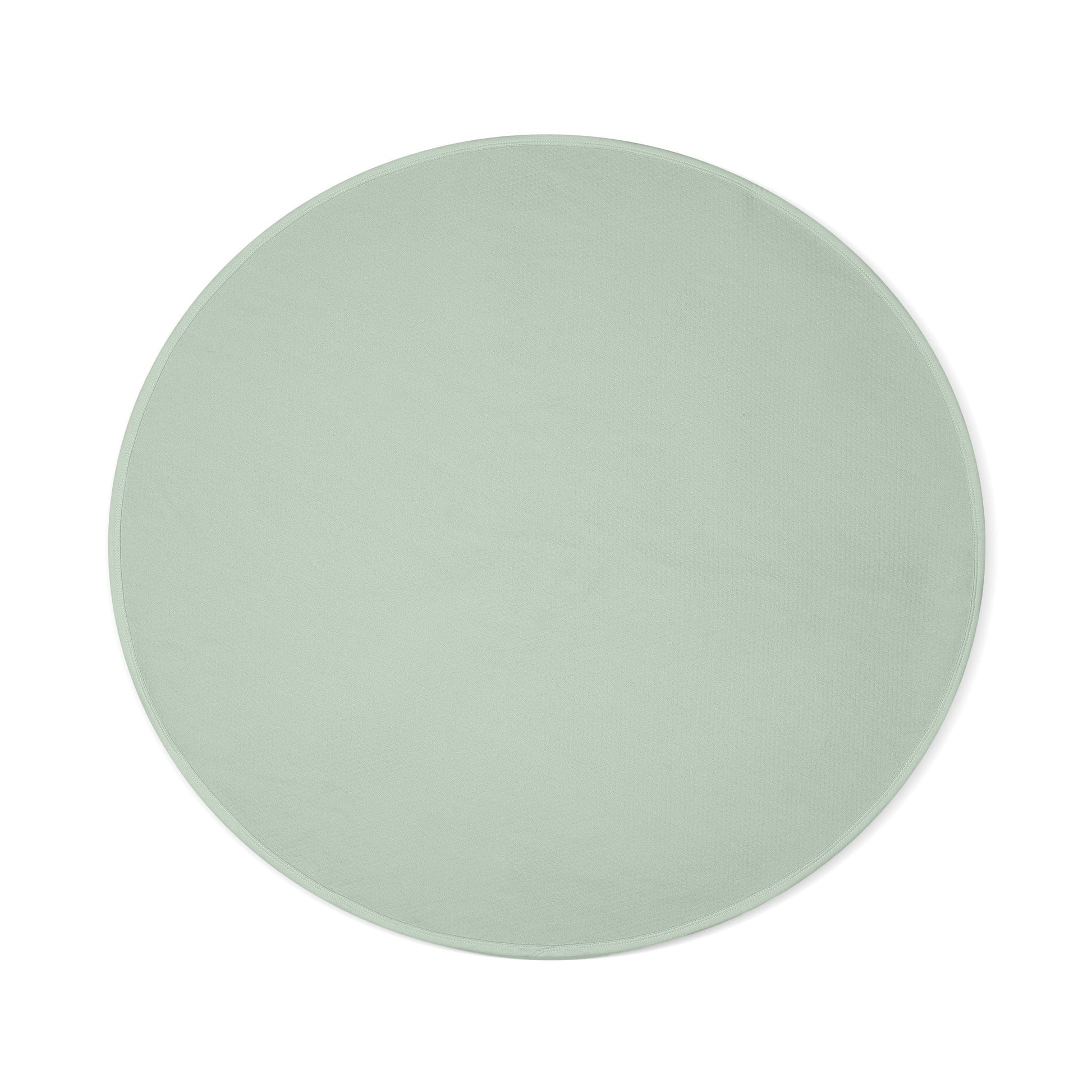 Sage green circular waterproof cotton blanket with a textured surface.
