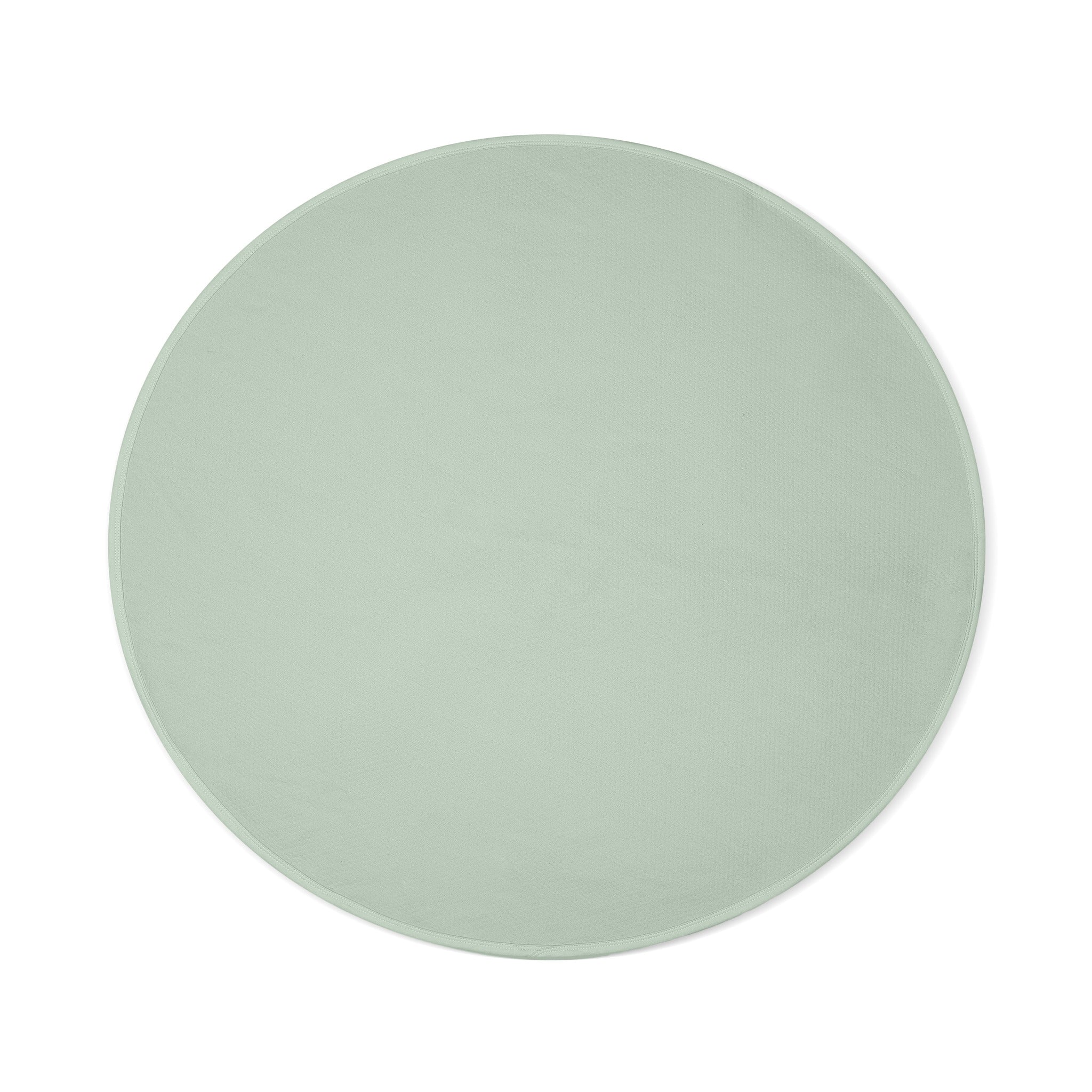 Sage green circular waterproof cotton blanket with a textured surface.