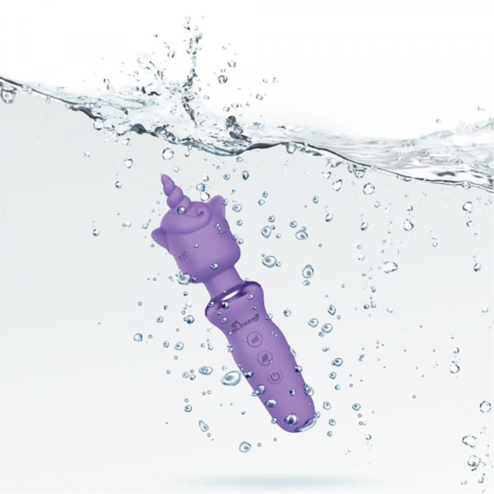 A lilac unicorn wand massager submerged in water with bubbles.