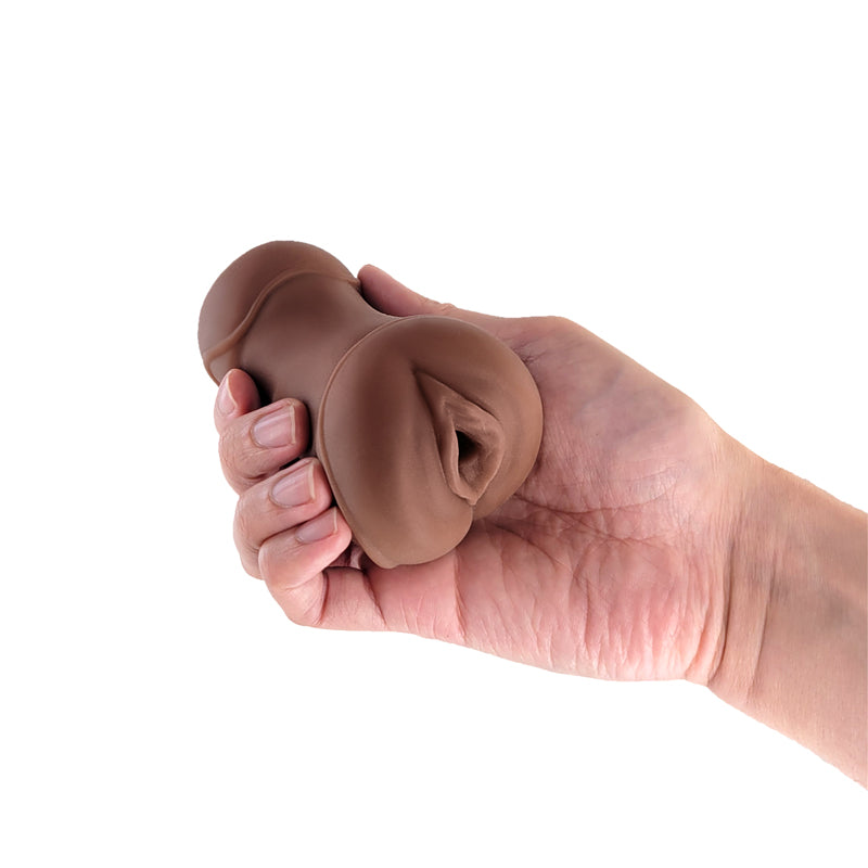 Brown TPE vagina stroker held in a hand.