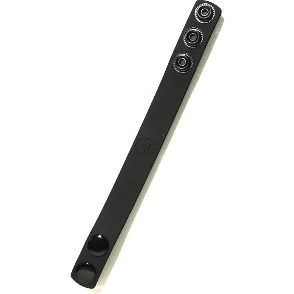 Black silicone cock strap with three snaps and a skull emblem.