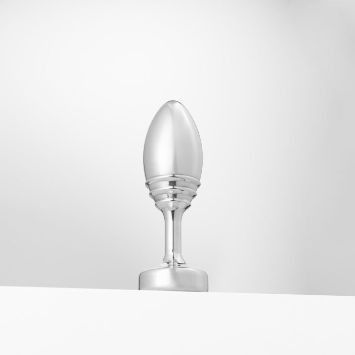 Weighted aluminum butt plug with ribbed detail and a flat base.
