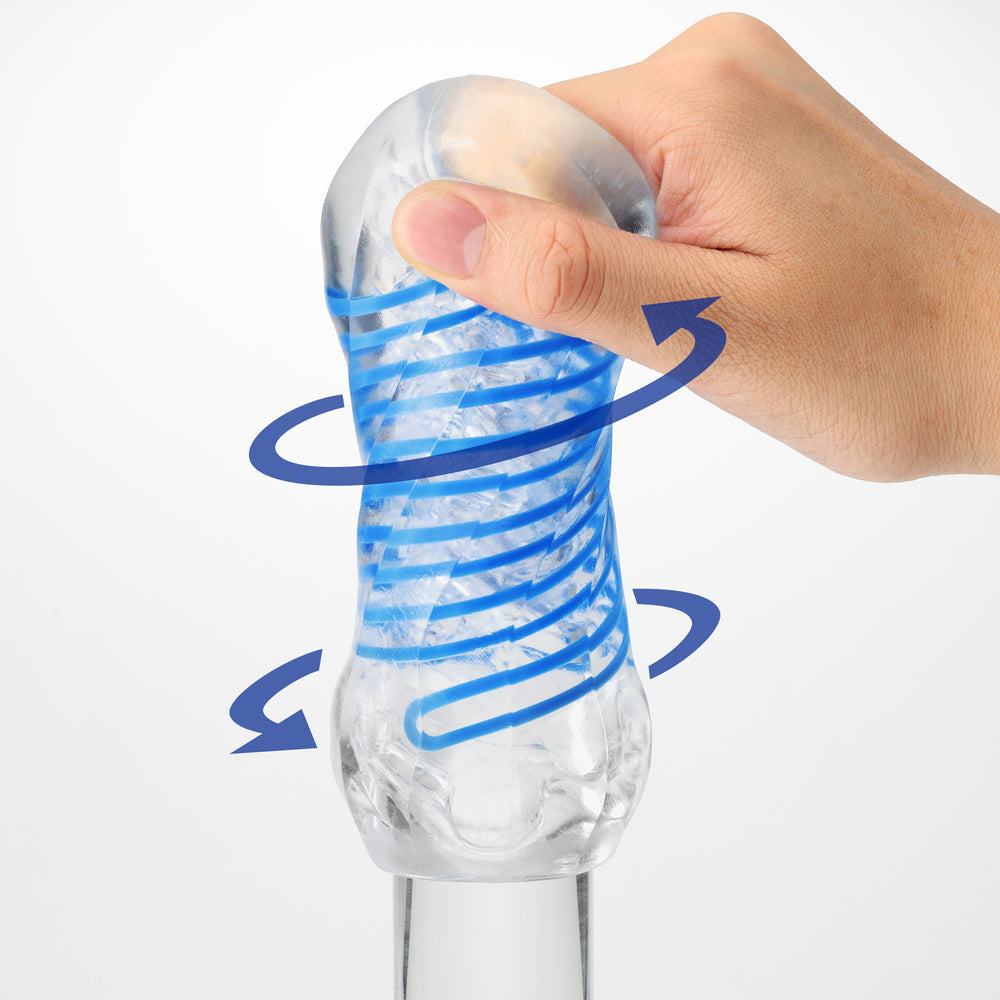 A hand grips a clear stroker with blue spiral inserts, with arrows indicating rotation.