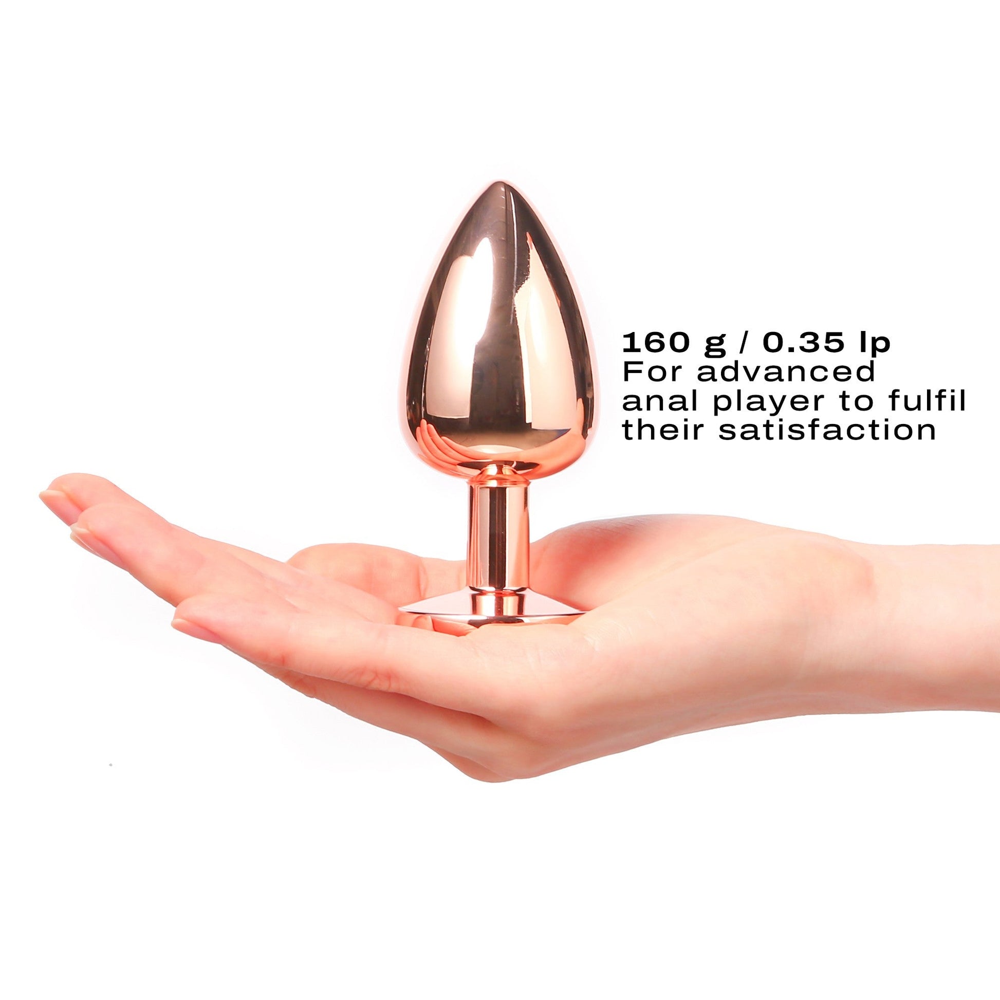 A large rose gold metal anal plug with a diamond base rests on a hand.