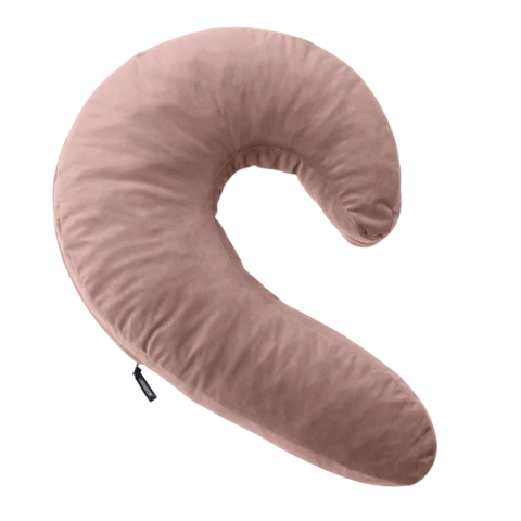 A pink crescent-shaped pillow with a soft velvet cover.