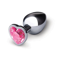 A silver metal anal plug with a pink heart-shaped gem base.