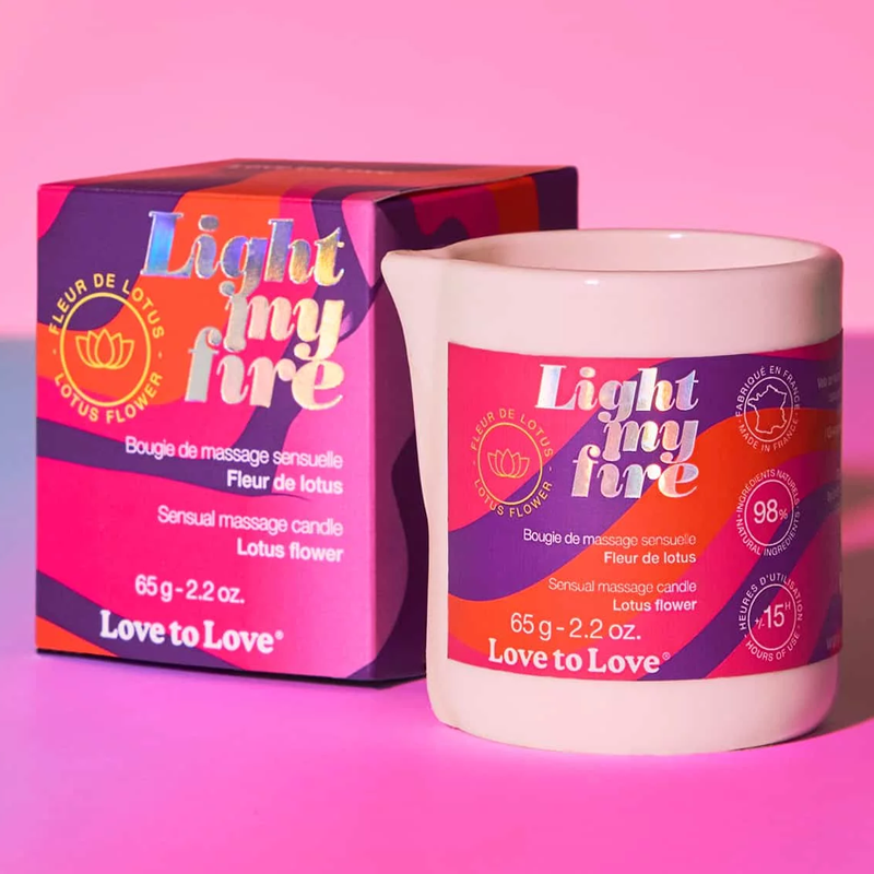 Lotus Flower massage candle in a white ceramic vessel with a colorful label.