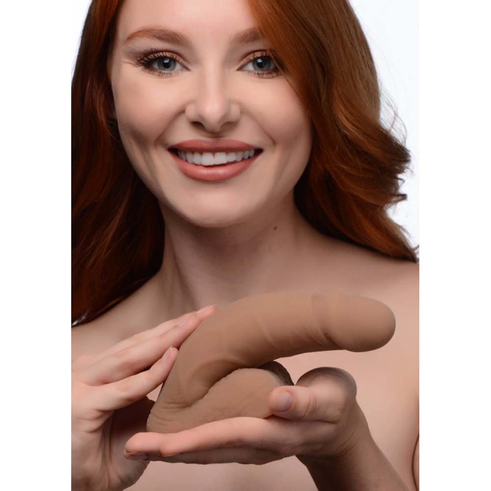 A large, soft, tan packer dildo with realistic details.